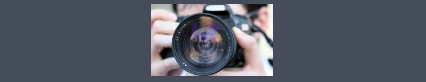 How to Make Money with Stock Photography.
Medium gray background. Square in the center, black camera, unfocused hands and part of a forehead with dark hair. Camera lens in the center. 